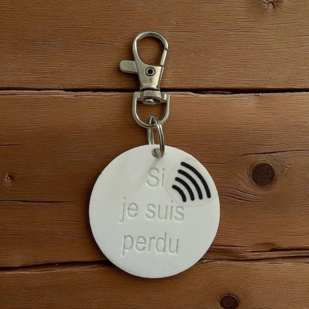 Badge rond blanc gravé Si je suis perdu avec icône NFC, fond bois foncé — variante NFC